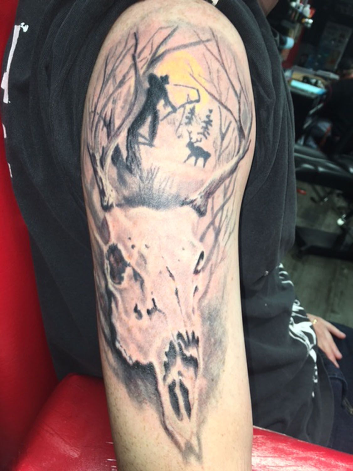 A man has a tattoo of a deer skull on his arm.