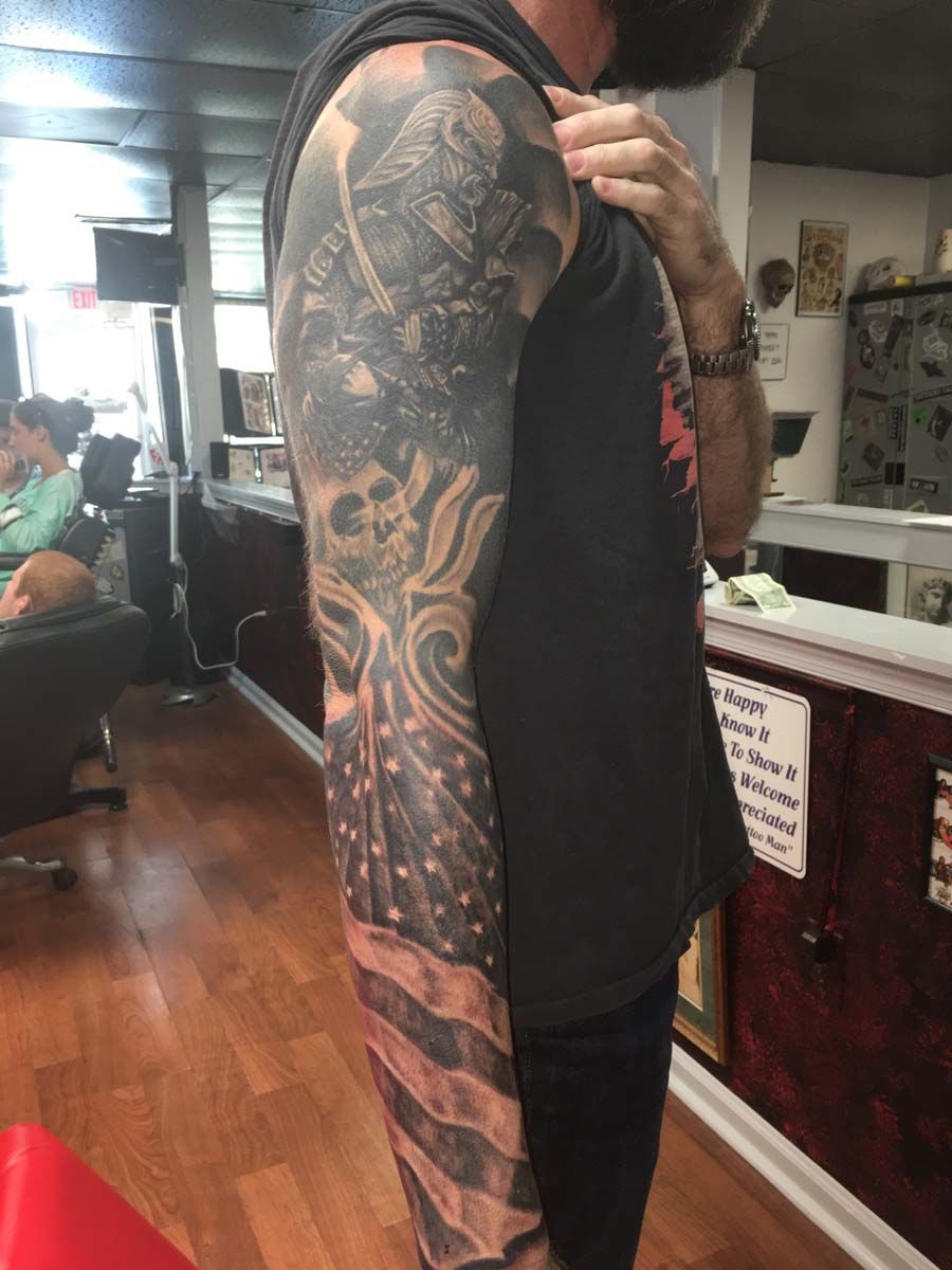 A man with a full sleeve tattoo on his arm