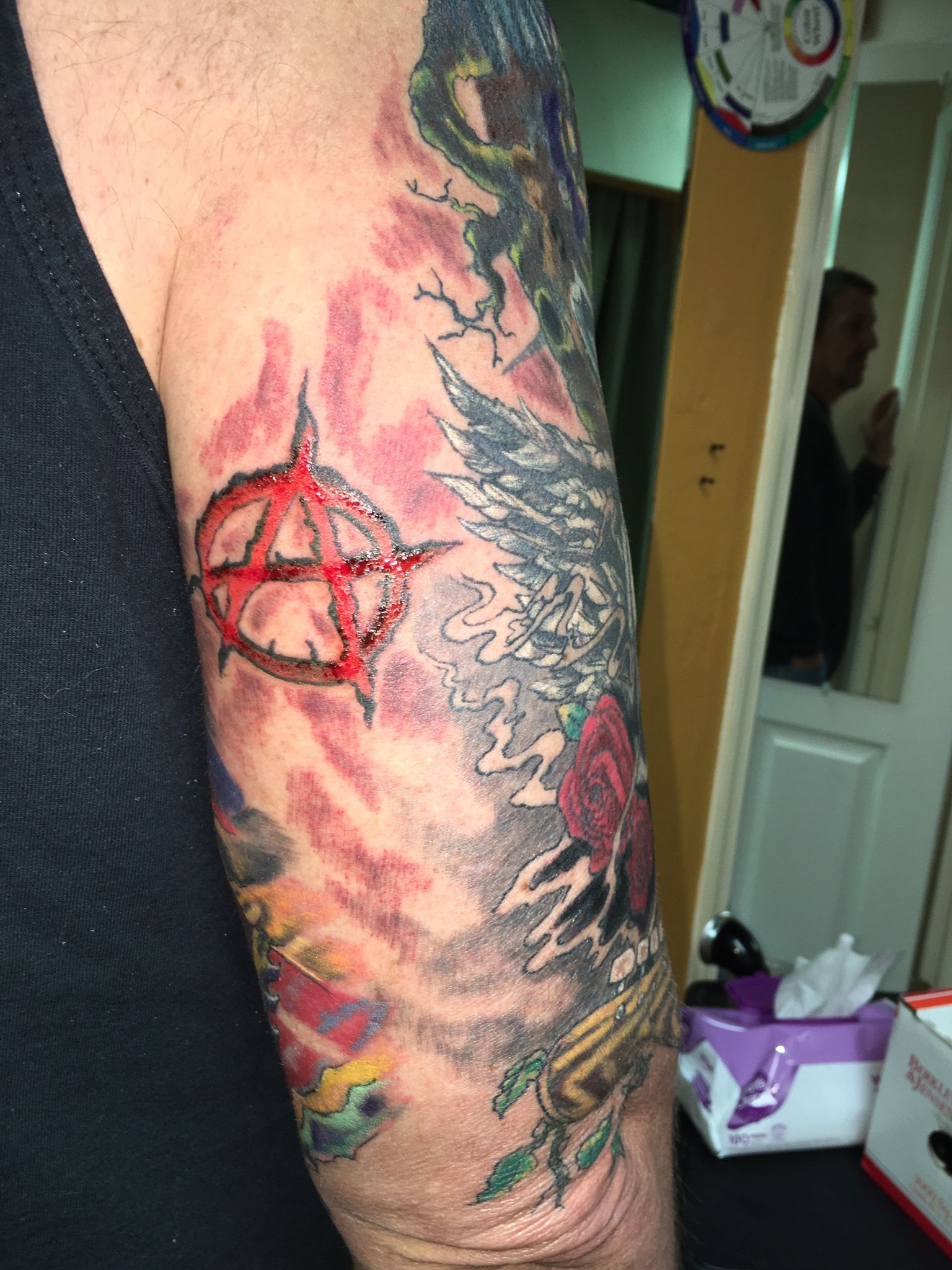 A man has a colorful tattoo on his arm.