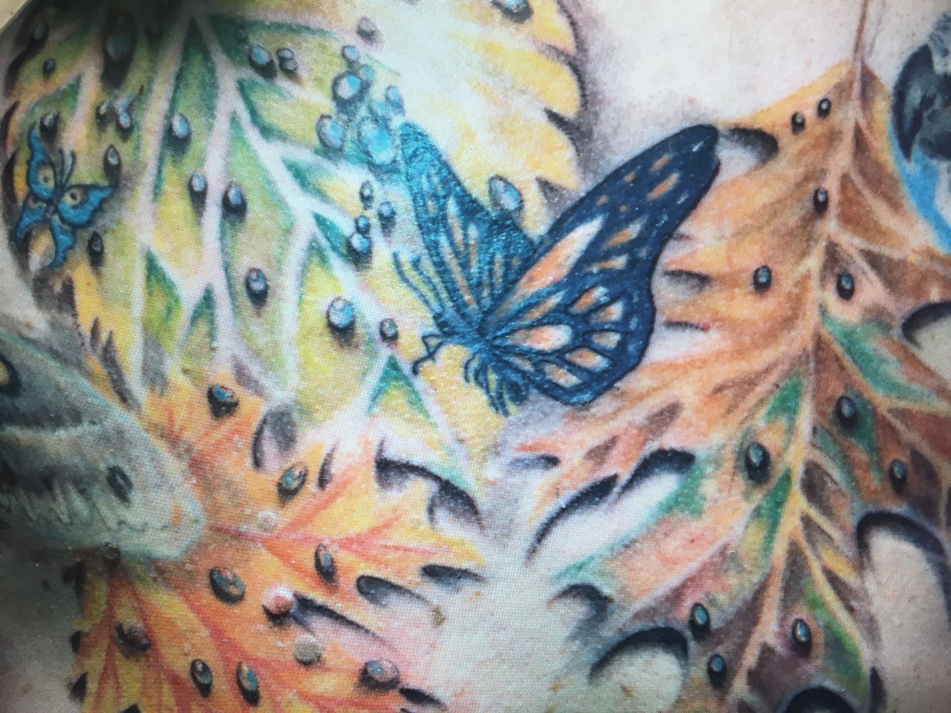 A close up of a butterfly tattoo on a person 's chest.
