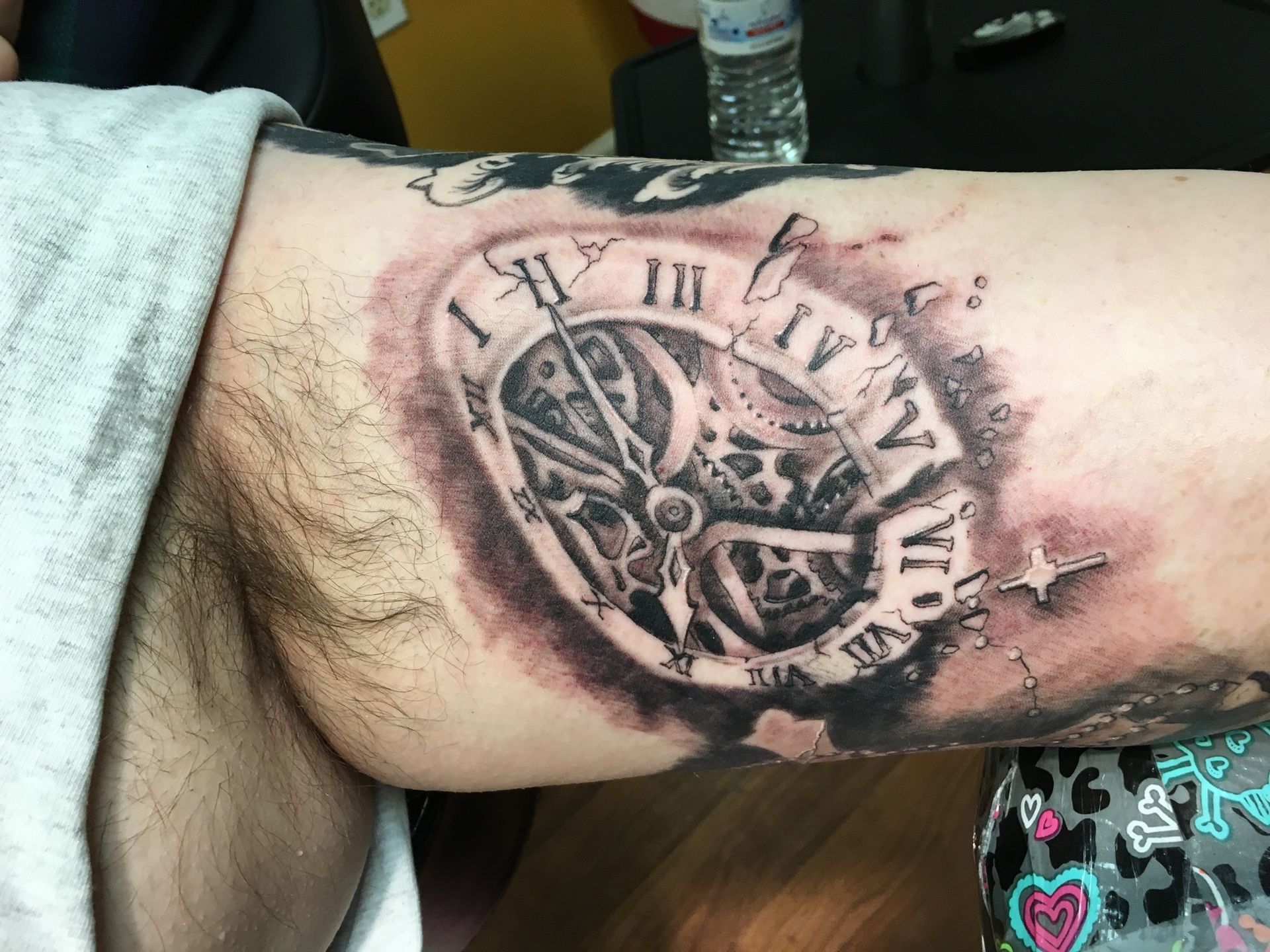 A man has a tattoo of a clock on his arm