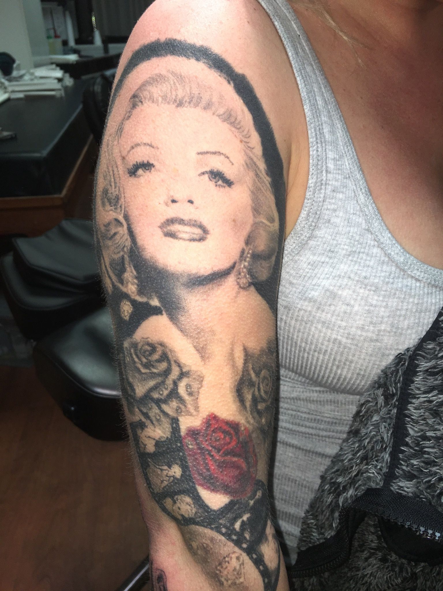 A woman has a tattoo of marilyn monroe on her arm
