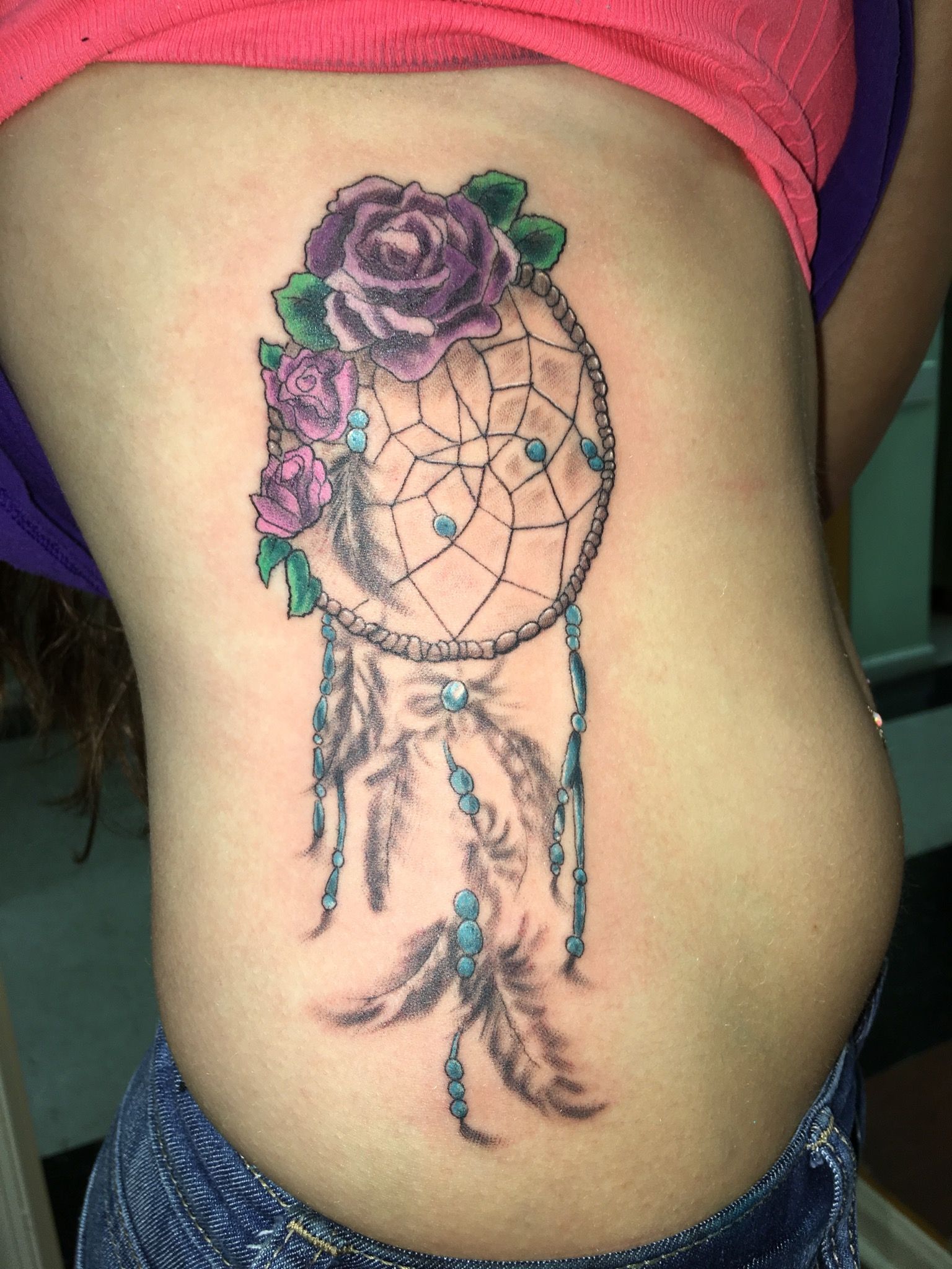 A woman has a dream catcher tattoo on her side