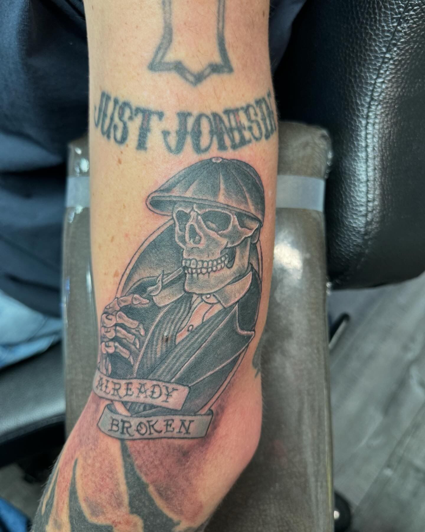 A man has a tattoo of a skeleton on his arm