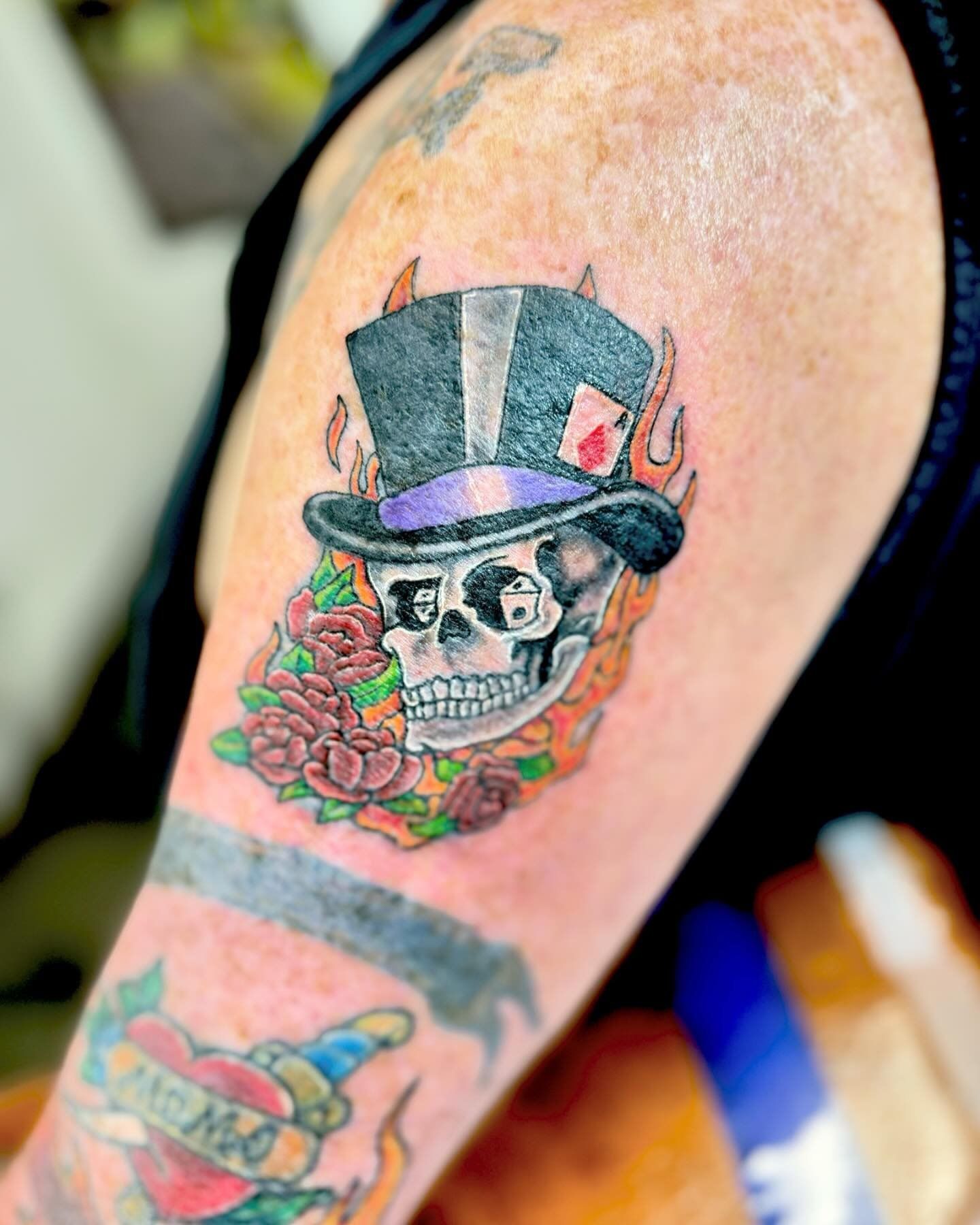 A man has a tattoo of a skull wearing a top hat