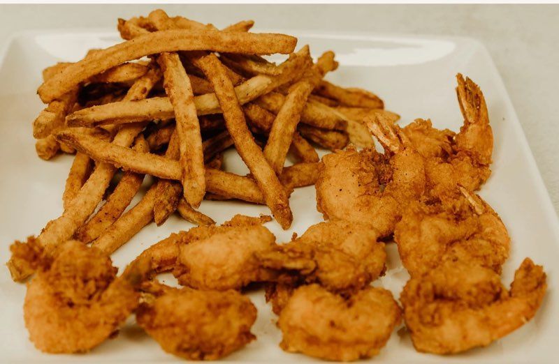 A white plate topped with fried shrimp and french fries.