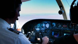 A male pilot is flying in Alice Springs