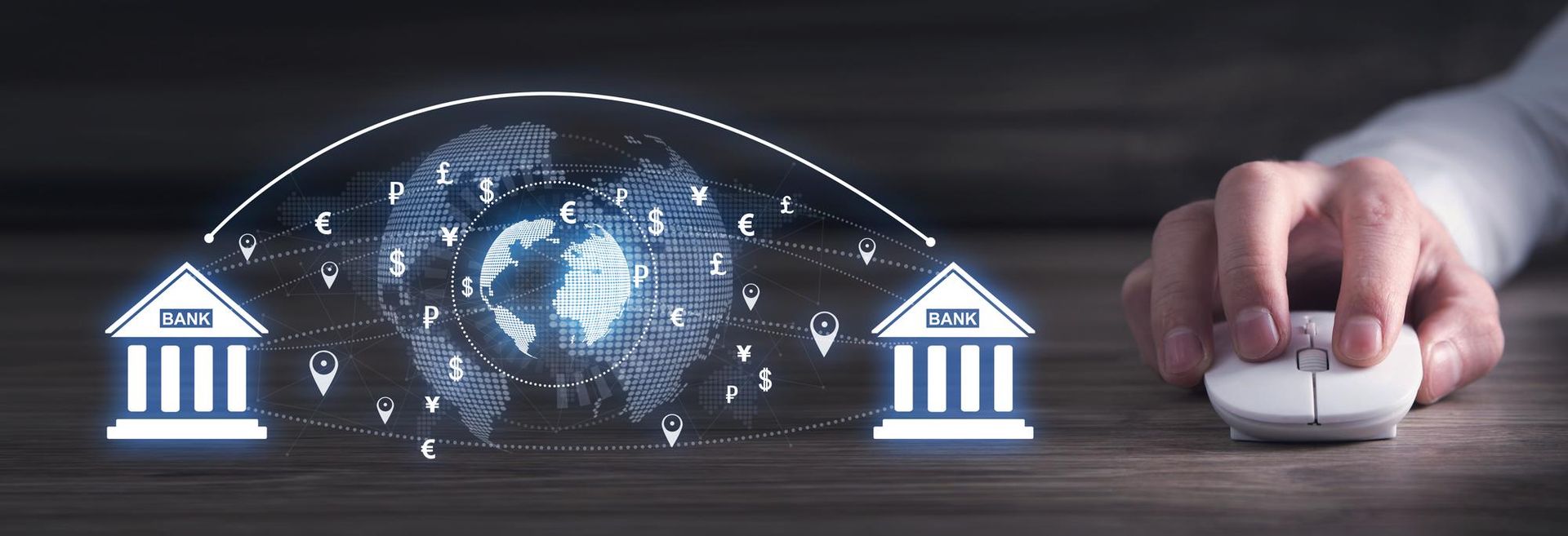 A hand clicks a computer mouse, connecting two digital bank icons with a glowing globe showing various currency symbols.