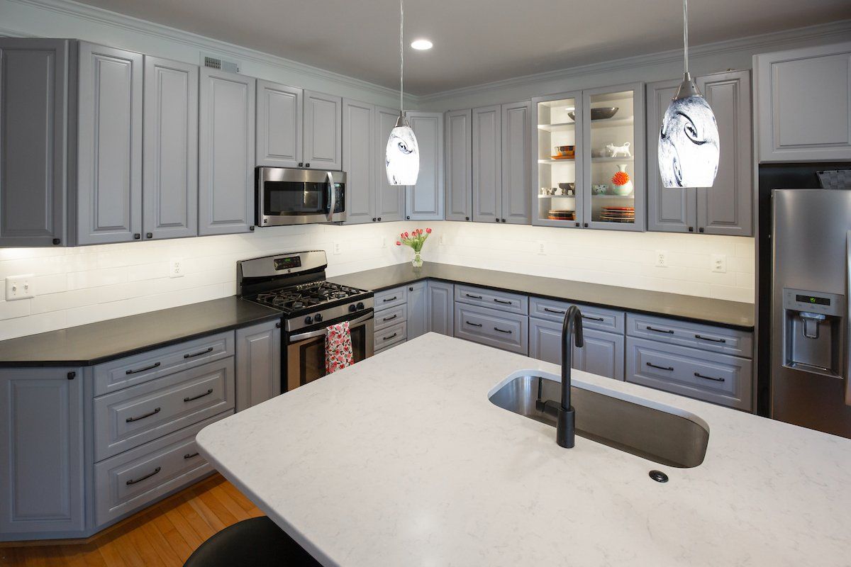 Absolute Black Honed Granite Perimeter Countertops, Lagoon Silestone Island Top, Glazzio Ice Mist Tile Backsplash, Waypoint Painted Stone Cabinets