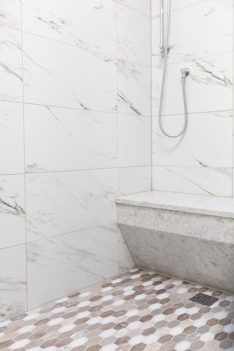 Lazer Carrara Tiled Shower Wall and Bench, and Bellagio Blend Accent Tile on Shower Floor