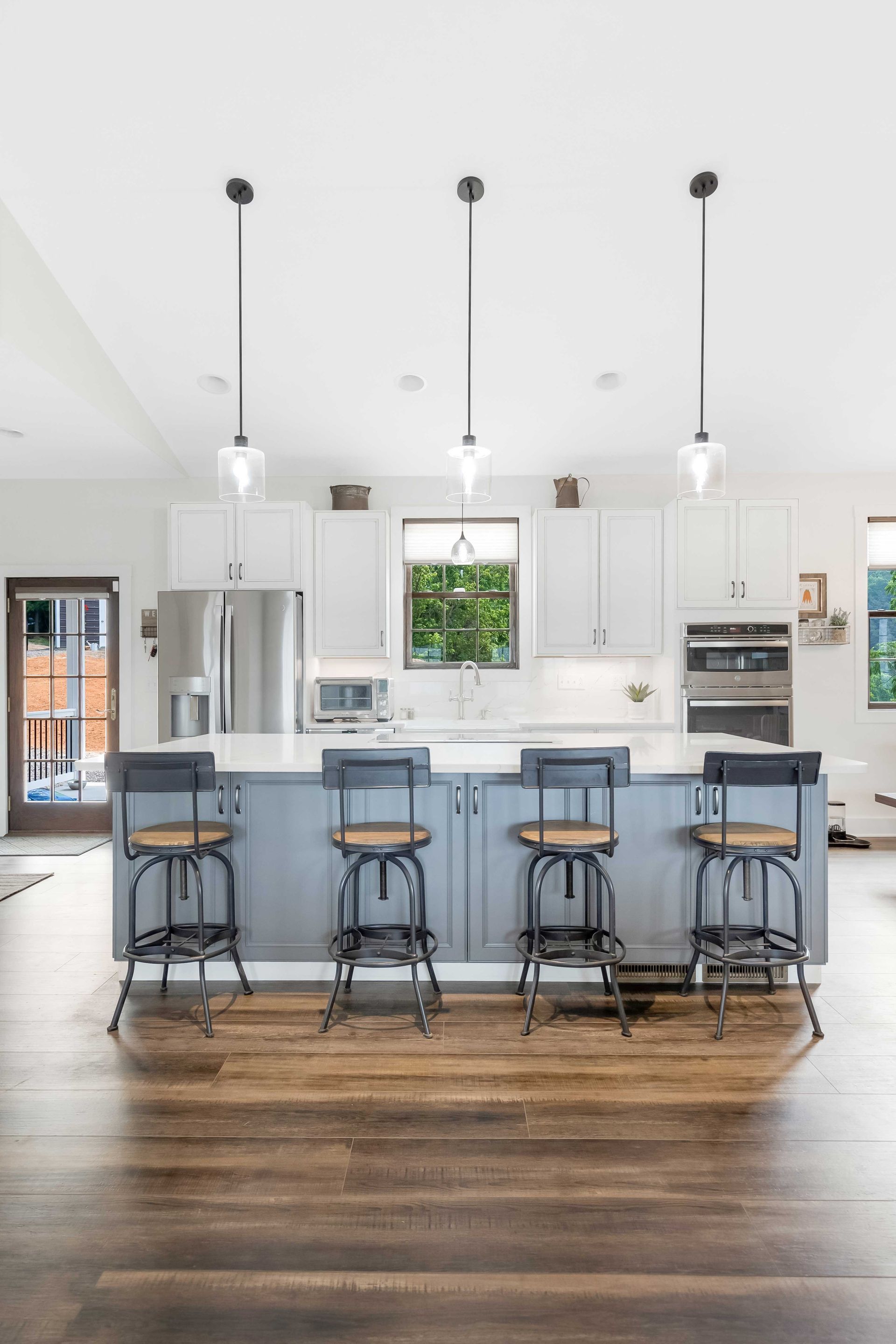 Waypoint Painted Boulder Island Cabinet, Waypoint Painted Pewter Perimeter Cabinets, and Calacatta Laza Q Quartz Countertops