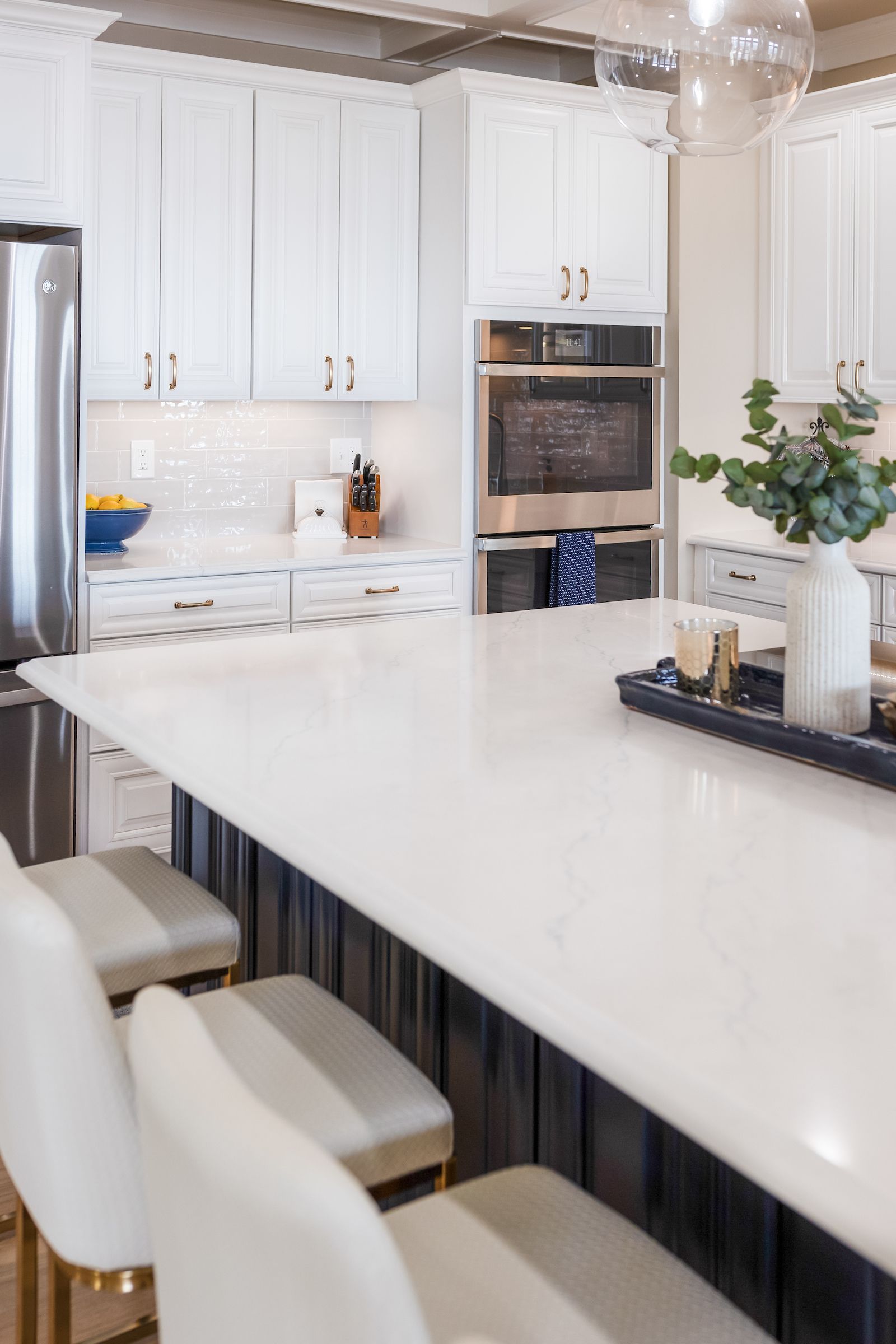 Calacatta Miraggio Cielo Q Quartz Countertops, Armonie Picadilly Avorio Glossy Tile Backsplash, Waypoint Painted Linen Perimeter Cabinets, and Painted Navy Island Cabinets