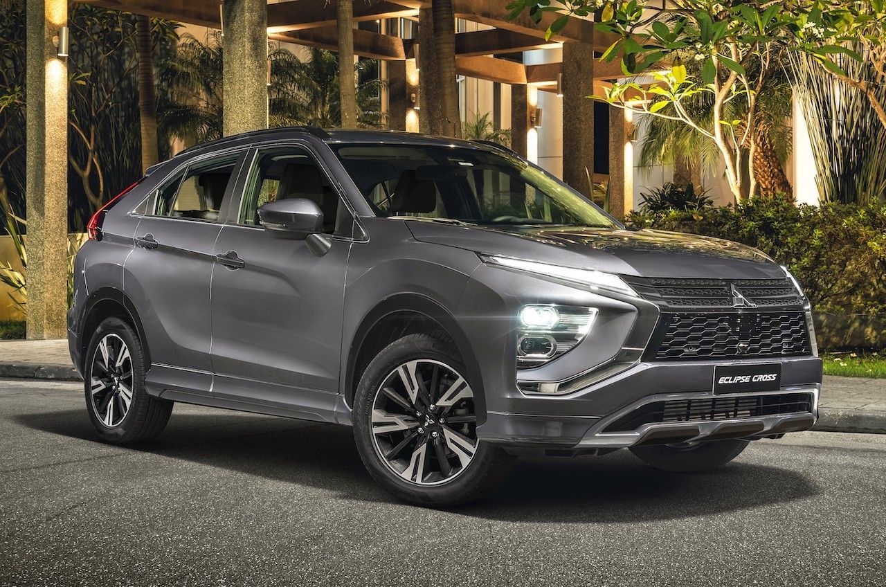 SUV Mitsubishi Eclipse Cross cinza estacionado em uma rua asfaltada, iluminado pelos faróis.