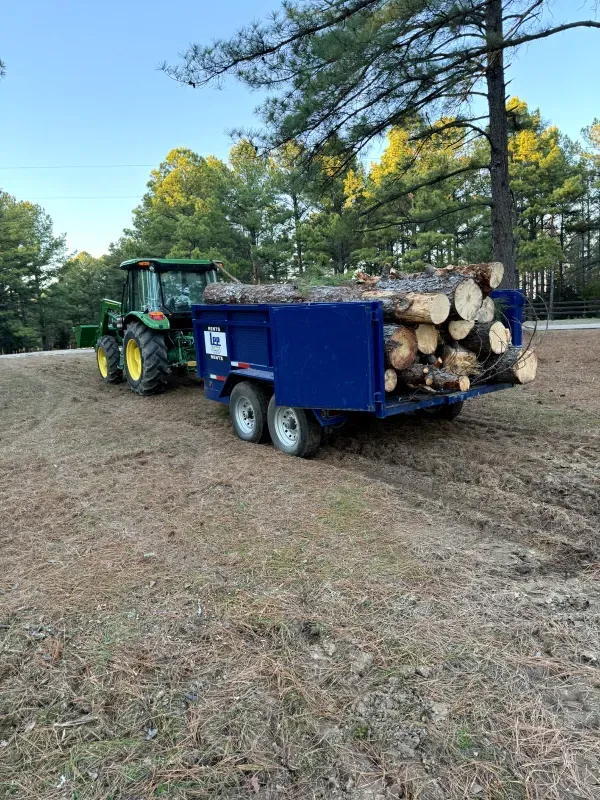 A tractor is pulling a trailer full of logs.