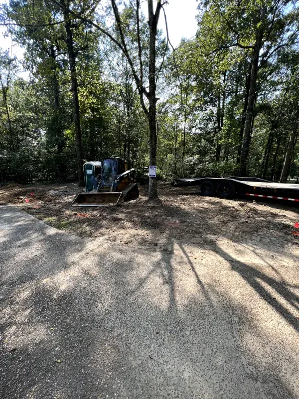 A trailer is sitting on the side of a road in the middle of a forest.