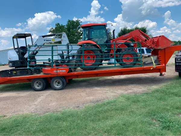 A tractor is sitting on top of a trailer.