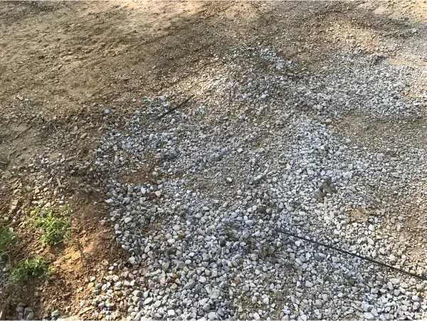 A pile of gravel is sitting on top of a dirt field.