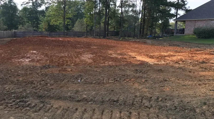 A large pile of dirt is sitting in front of a house.
