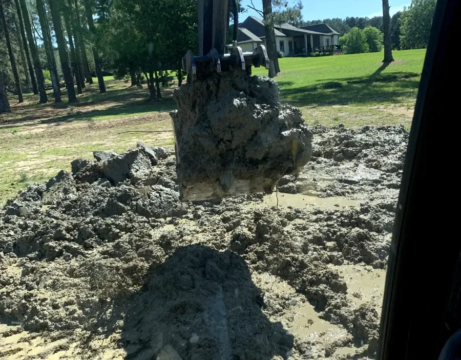 A large pile of dirt is being excavated in a field