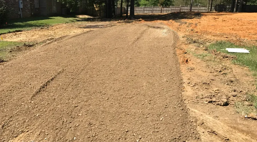 A dirt road leading to a baseball field.