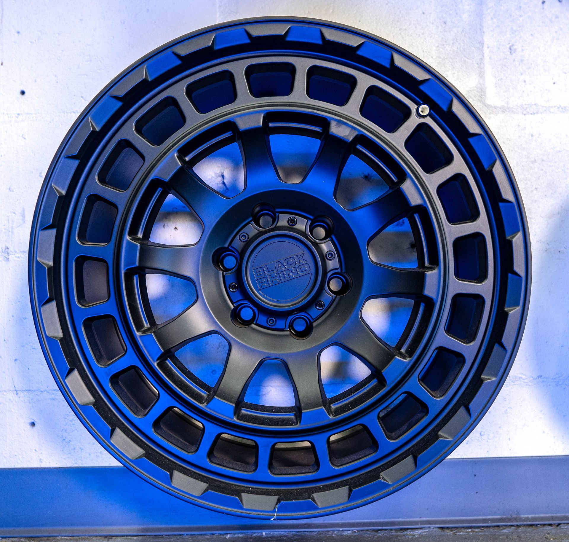 A close up of a black wheel with a blue rim