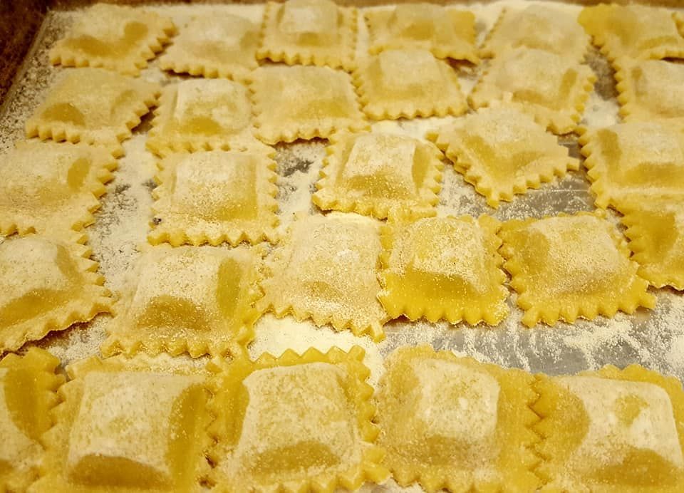 Un tavolo in un ristorante con bicchieri, posate e un vaso sopra.