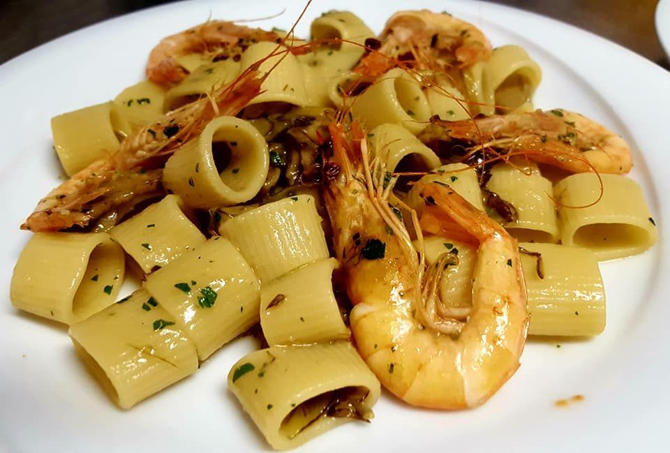 Un piatto di cibo e una bottiglia di vino su un tavolo.