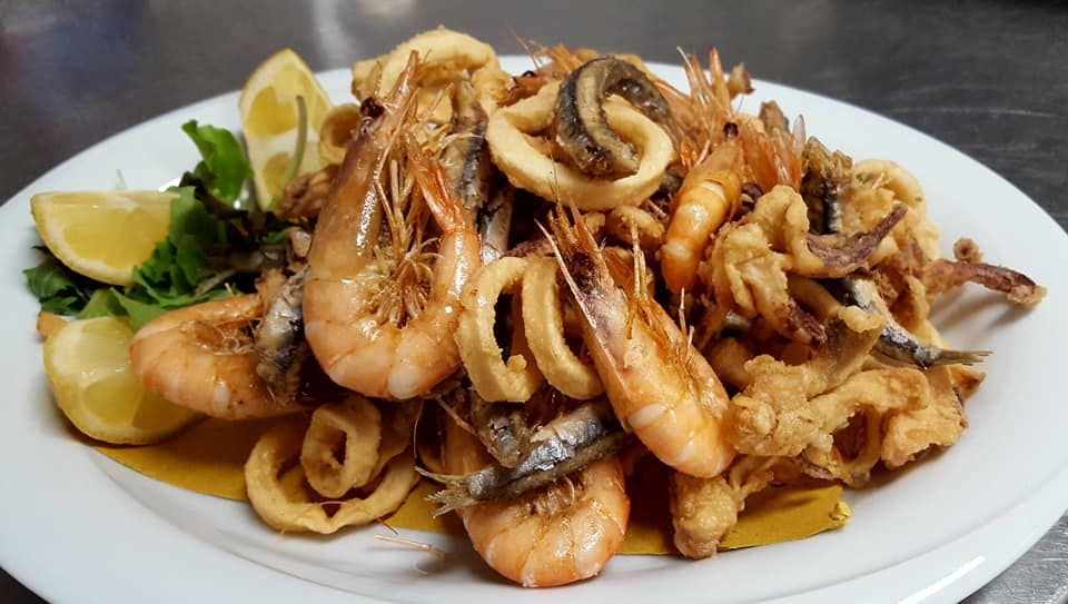 Una ciotola di salsa di pomodoro con un pezzo di pane dentro.