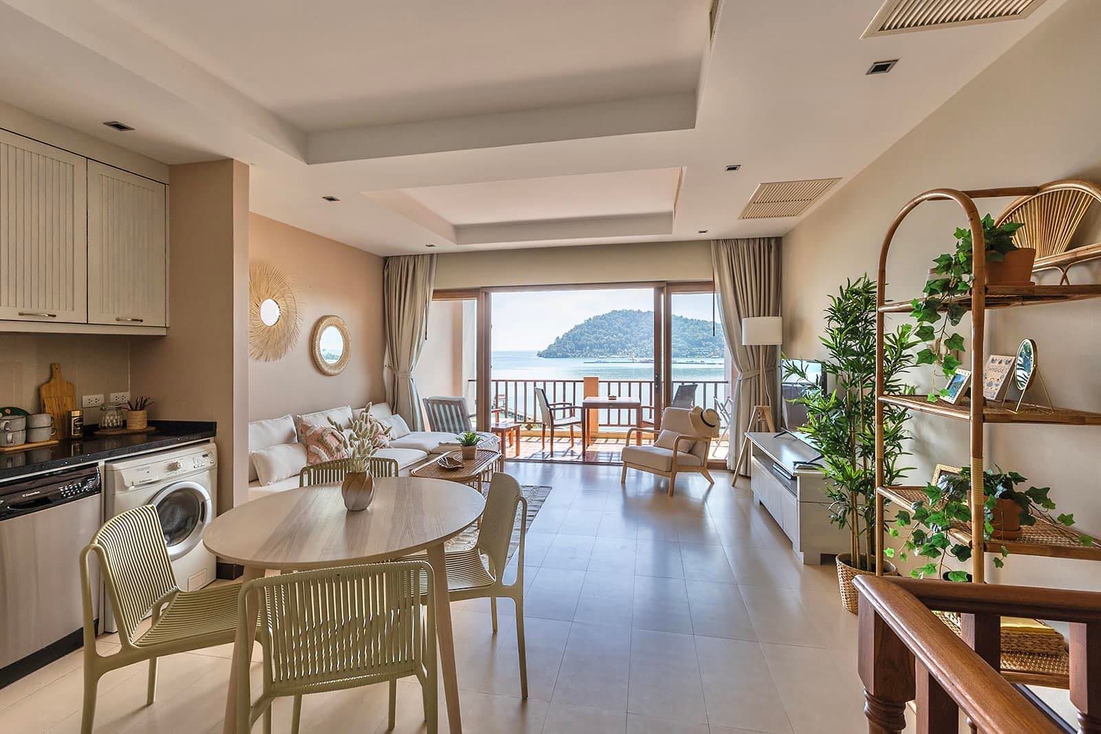 A living room with a table and chairs and a view of the ocean.