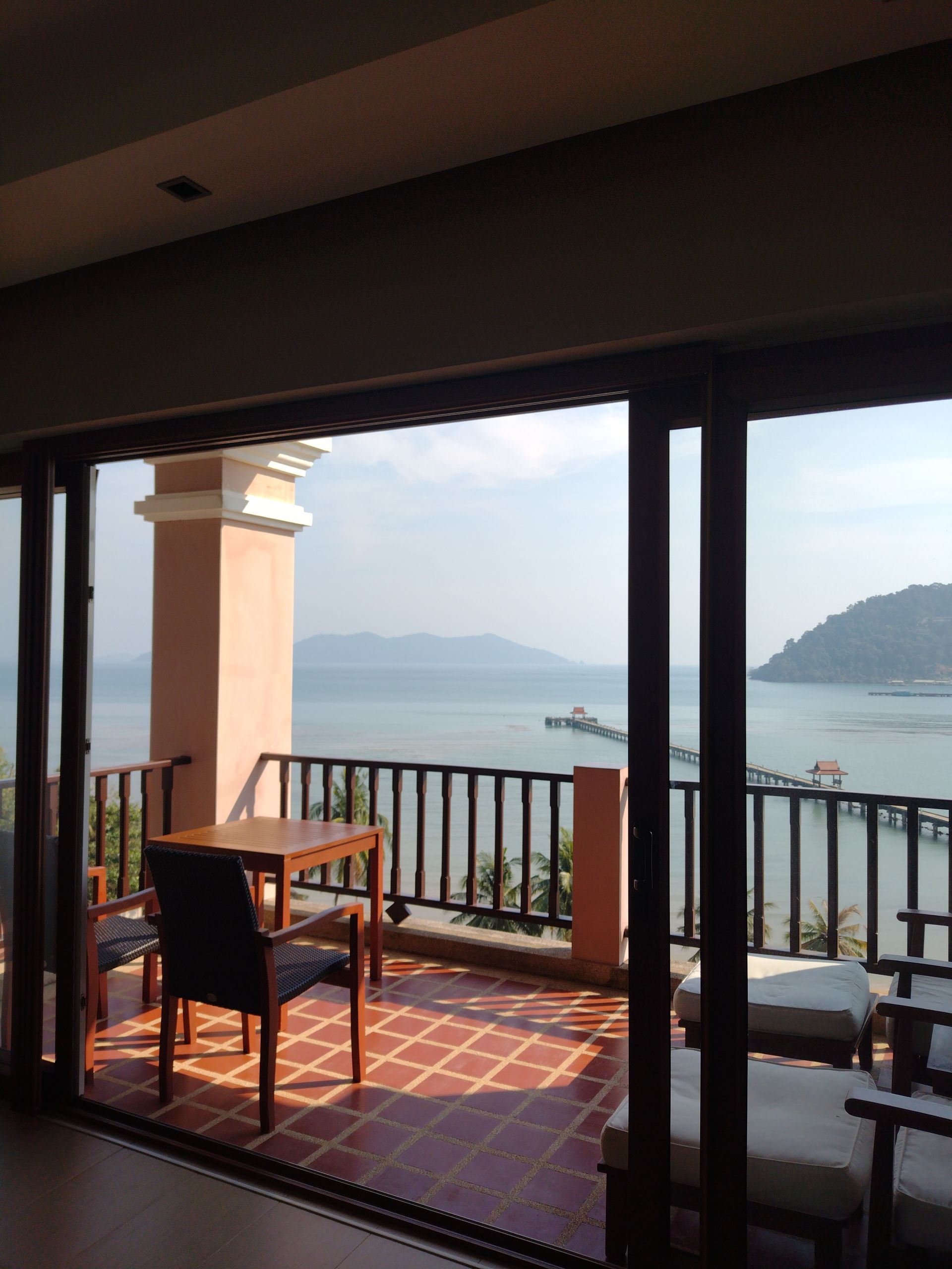 A bedroom with a large bed and lots of windows