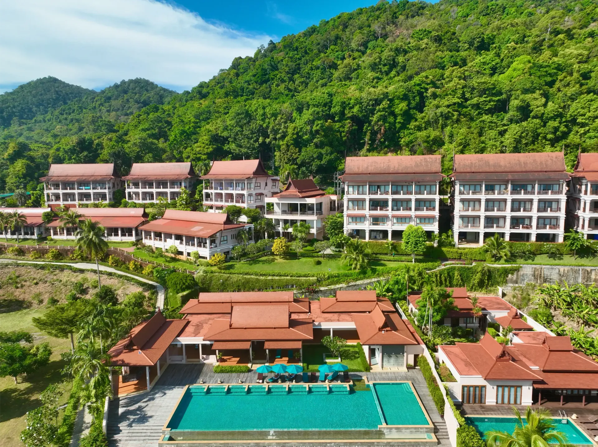 An aerial view of a resort with a large swimming pool surrounded by buildings.