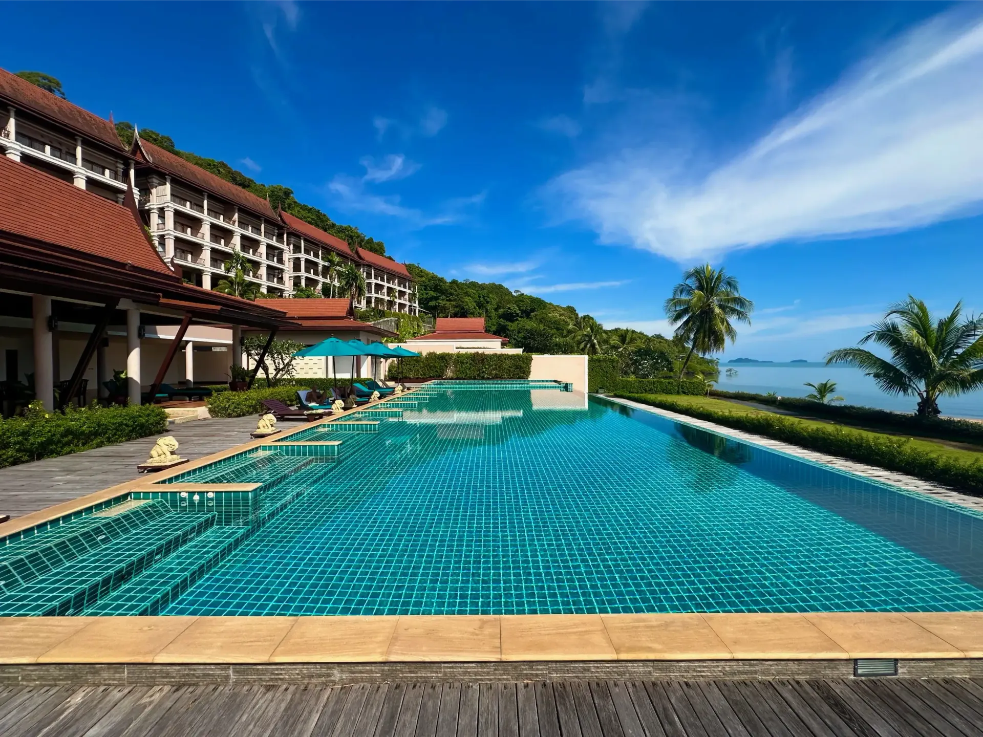 There is a large swimming pool in front of a building.