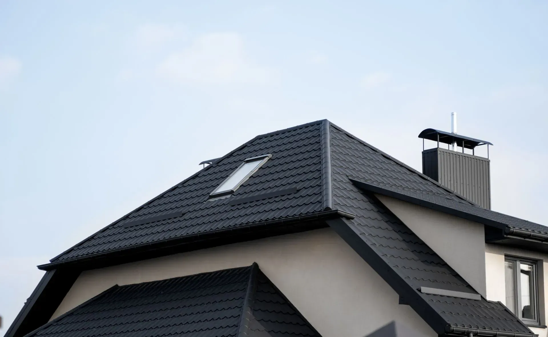 A house with a black roof and a skylight