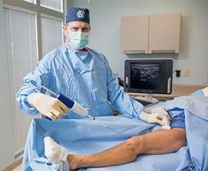 A surgeon is operating on a patient 's leg in a hospital.