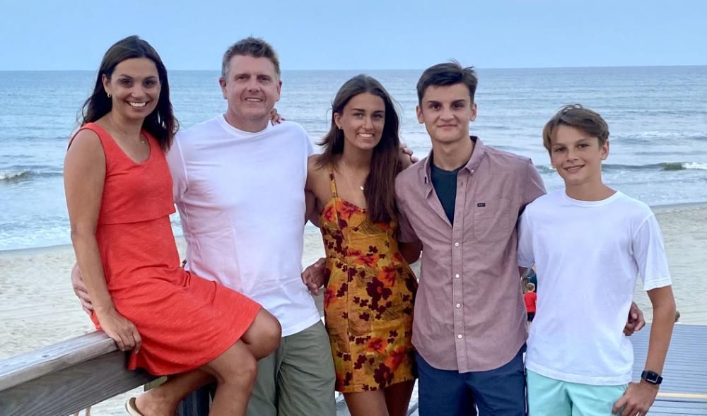 A family is posing for a picture on the beach.