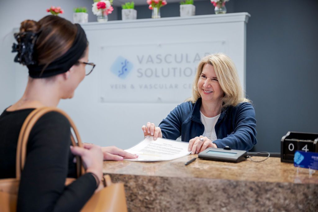A woman is sitting at a counter talking to another woman.