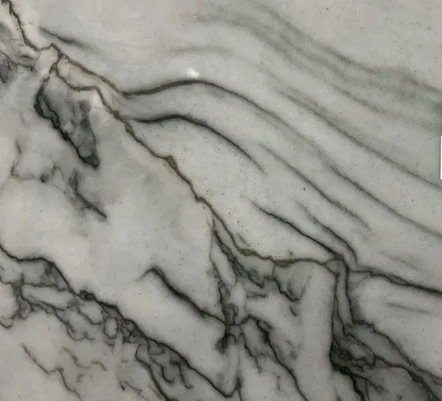 White marble with gray and black veining in diagonal waves.