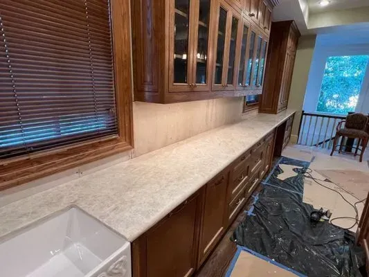 Kitchen with light countertops, dark wood cabinets, and a white farmhouse sink.