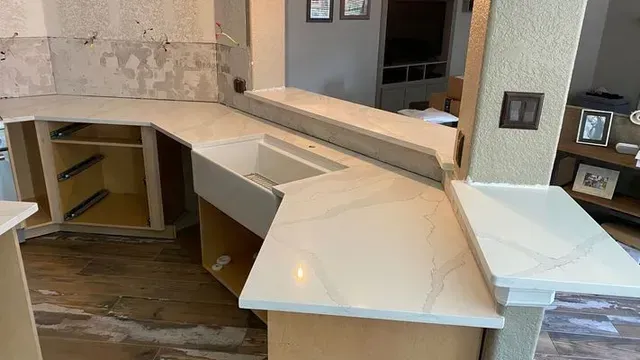 Kitchen remodel with white countertops, sink, and cabinets.