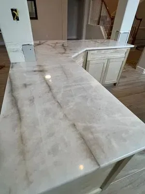 White and gray marbled epoxy kitchen countertops with cabinets in a newly renovated room.