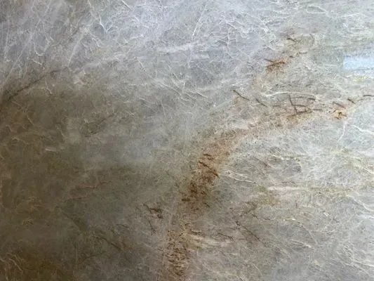 Gray and tan marble surface with veining and brown inclusions.