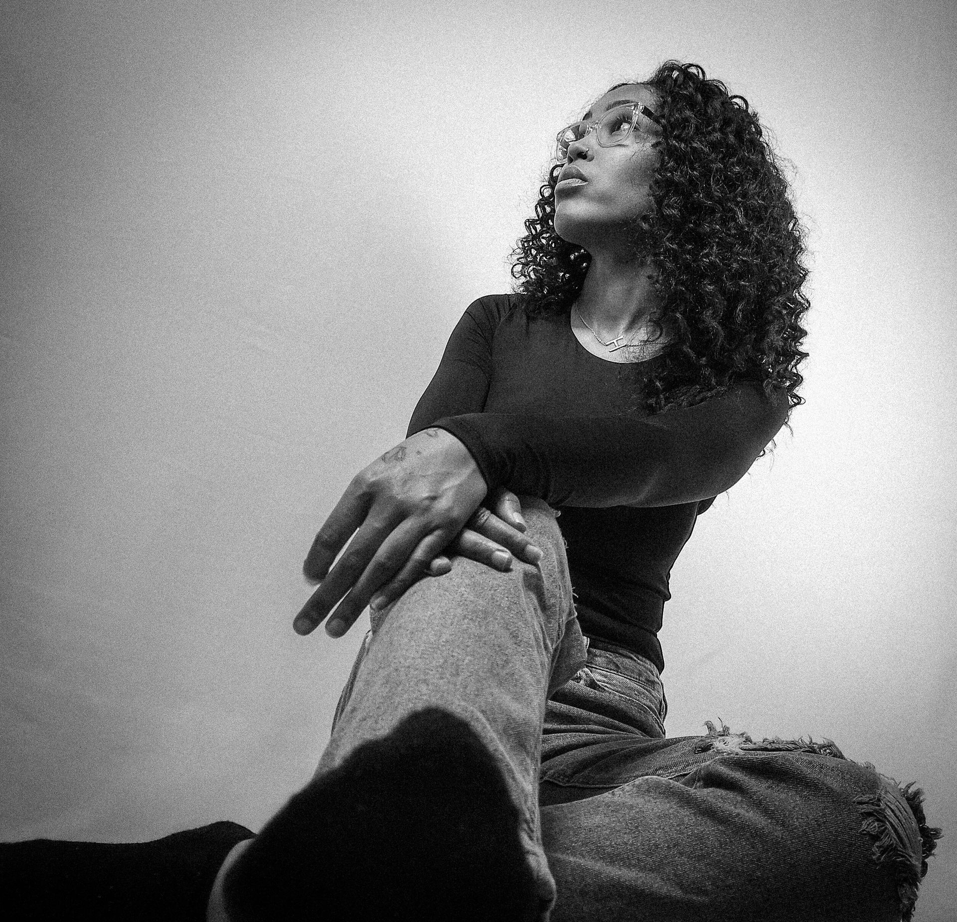 Hay Hay the Model posing in casual wear, showcasing her curly hair in a bright studio setting.