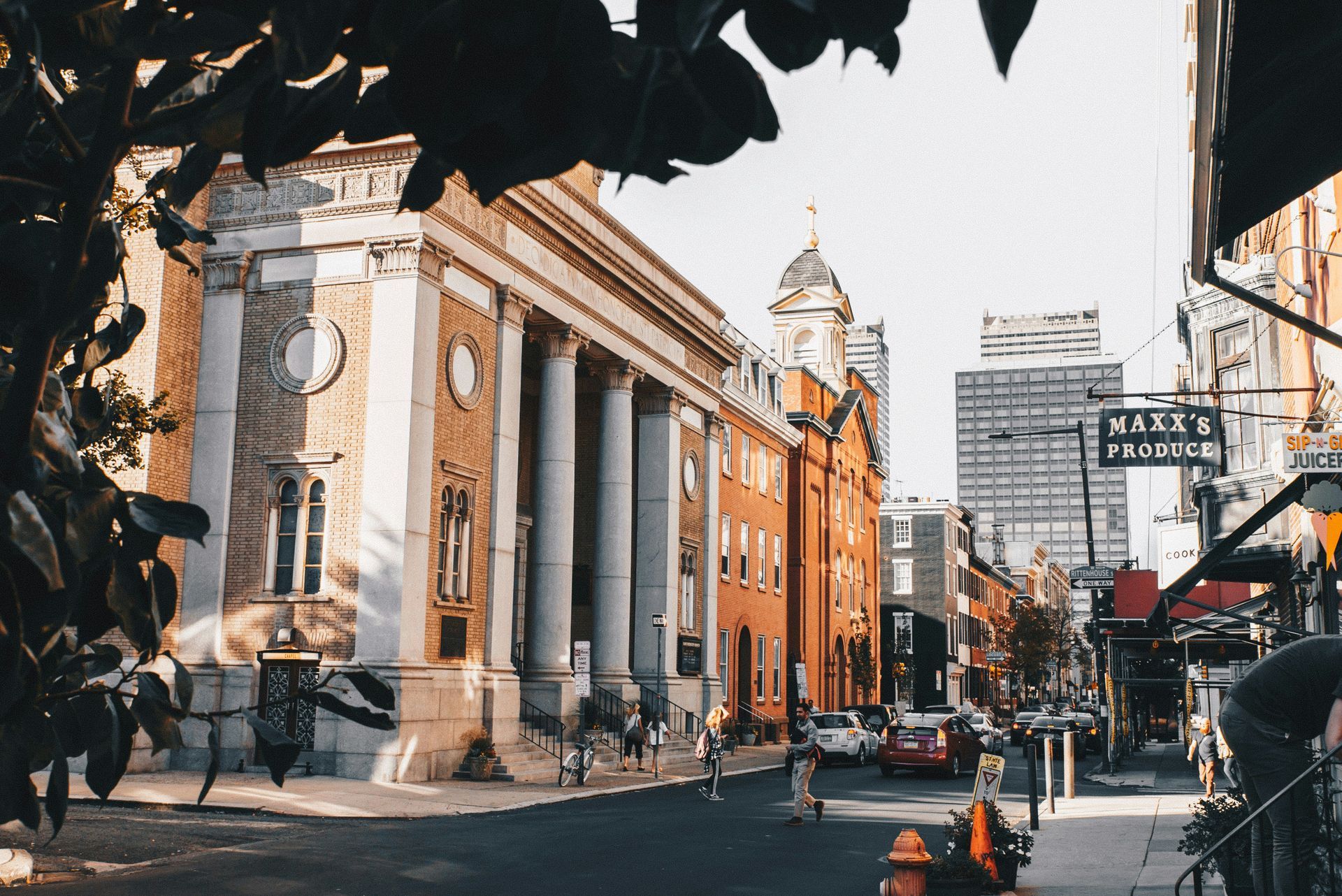 A city street with a fire hydrant in front of a large building.