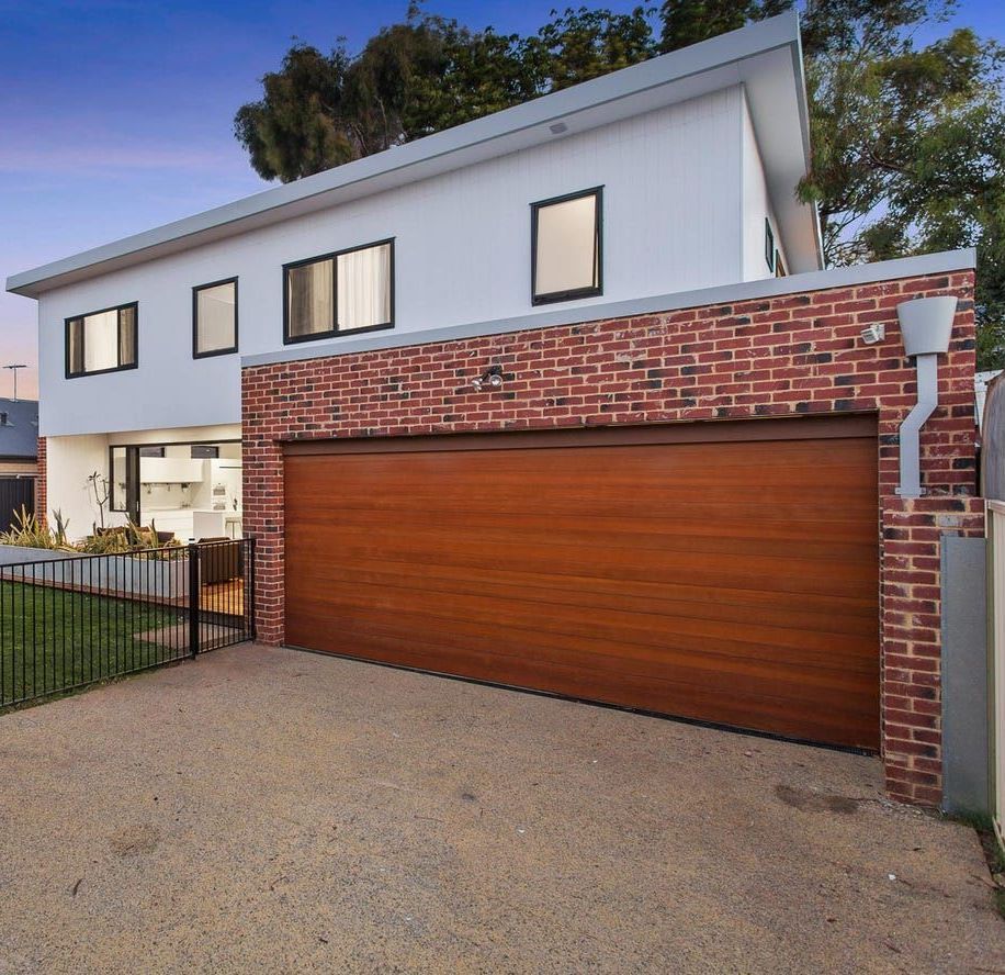 A Construction Worker is Kneeling Down and Spreading Concrete on the Ground — Premier Building QLD In Speewah, QLD