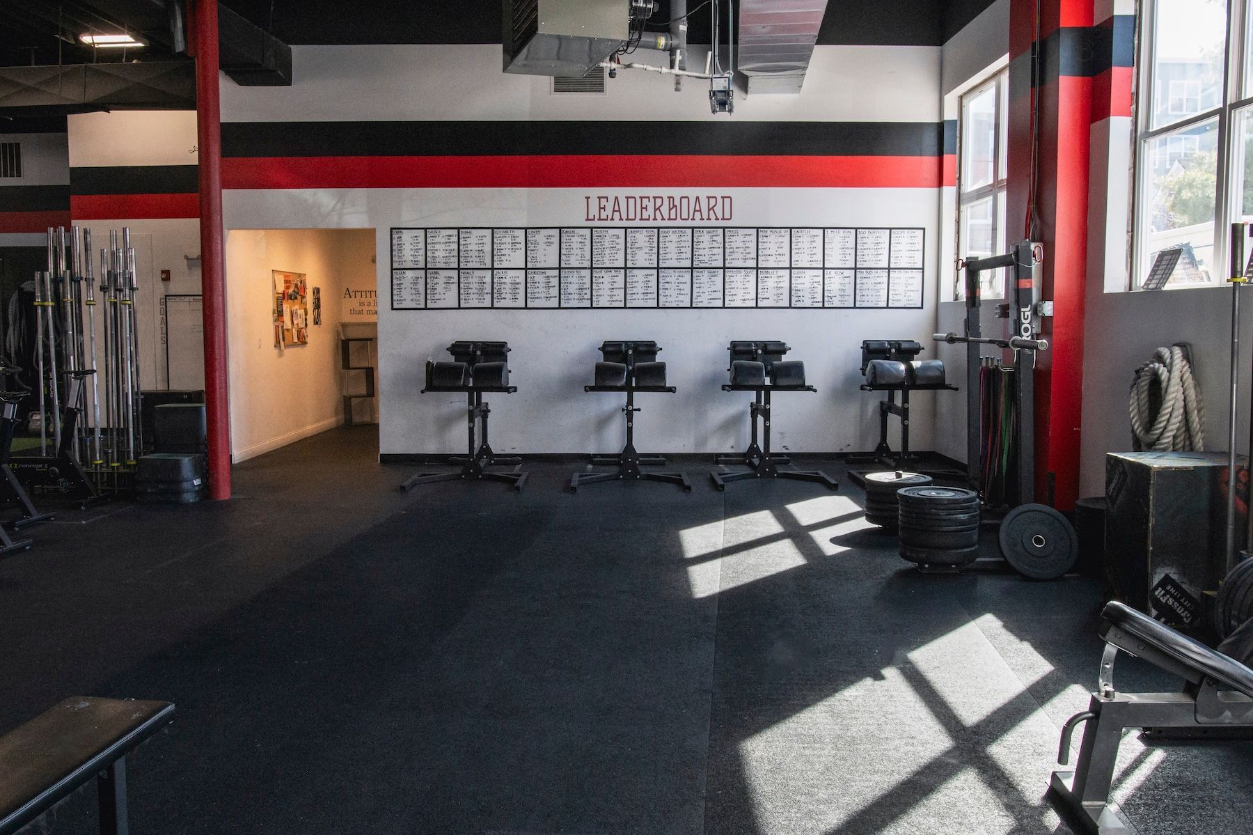 A gym with a lot of equipment and a sign that says ' infinite ' on the wall.