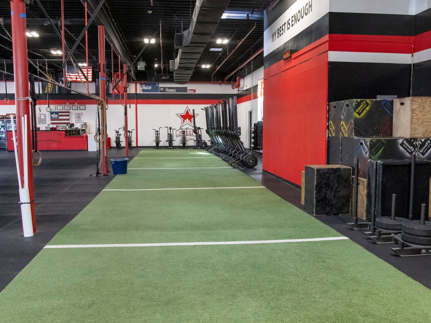 A gym with a long grassy area in the middle of it.