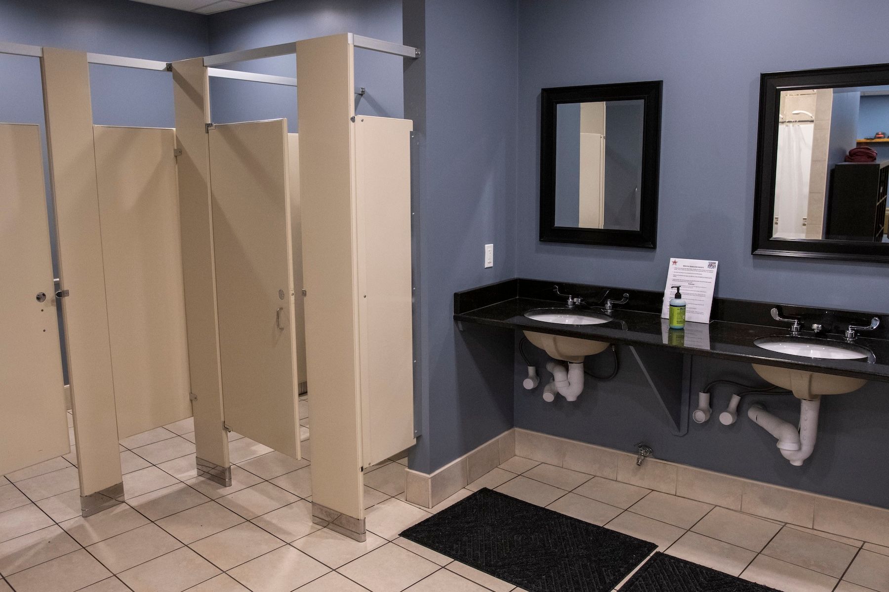 A bathroom with two sinks and two mirrors.