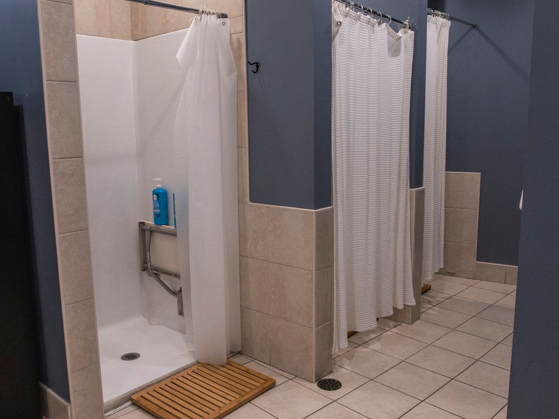A bathroom with a shower and a wooden mat