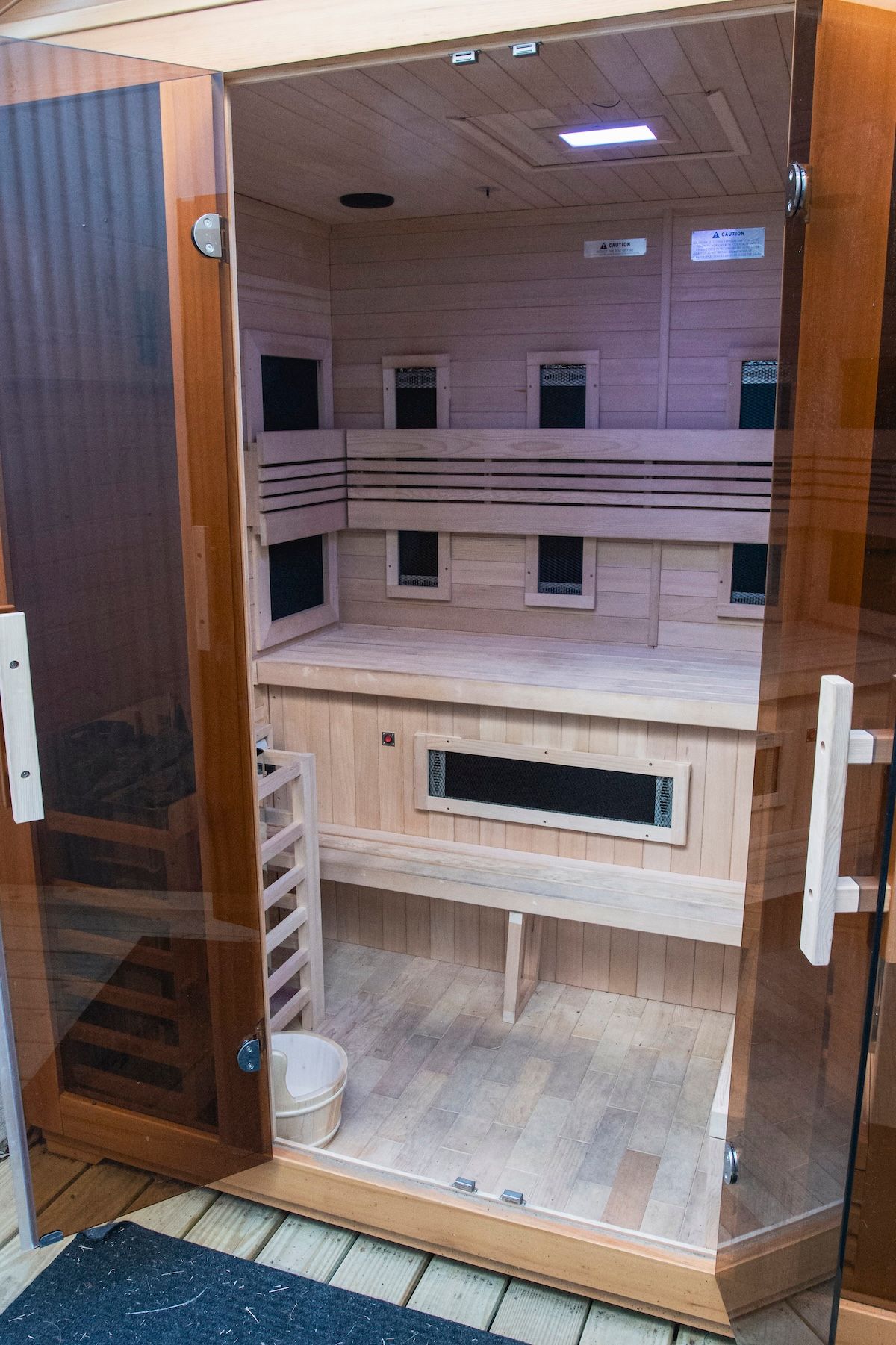 The inside of a wooden sauna with the door open.