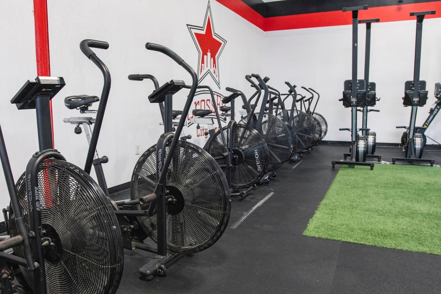 A row of exercise bikes are lined up in a gym.